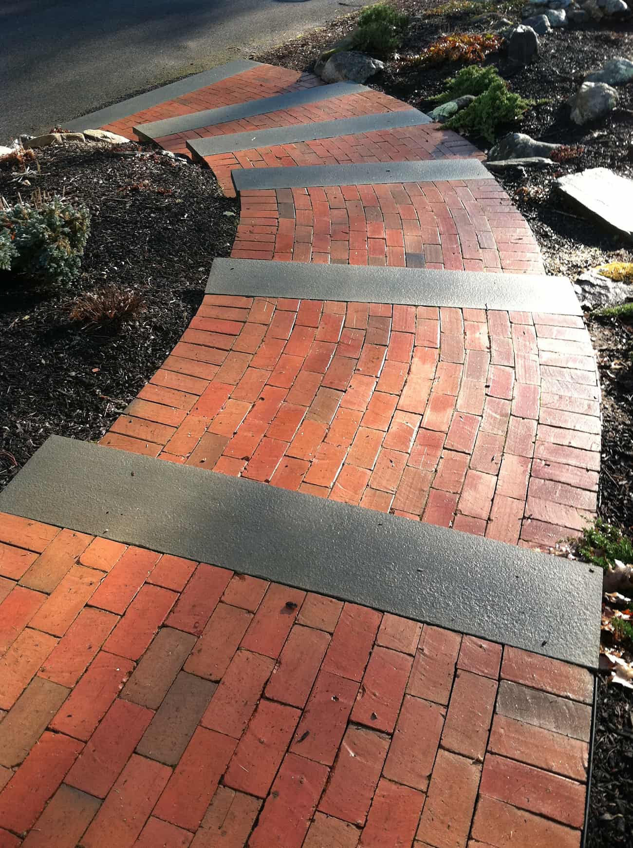 Brick pathway with stairs curving down a slope